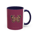 A ceramic mug with a deep magenta-pink exterior, a navy blue interior and handle, and a detailed butterfly graphic on the front.