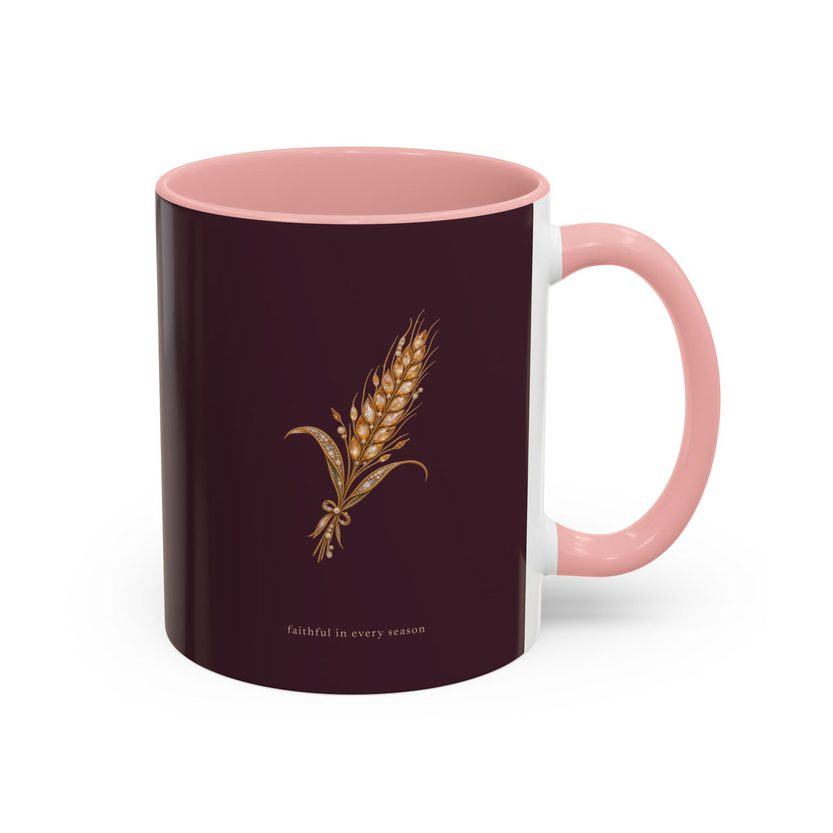 A ceramic mug with a deep burgundy exterior, a light pink interior and handle, and a gold wheat graphic with the text 'faithful in every season' on the front, shown on a white background.